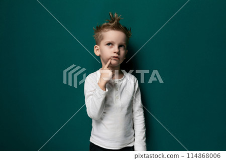 Little Boy Standing in Front of Green Wall Little Boy Standing in Front of Green Wall 114868006