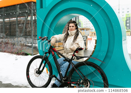 Woman Sitting on Bench Next to Bike Woman Sitting on Bench Next to Bike 114868506