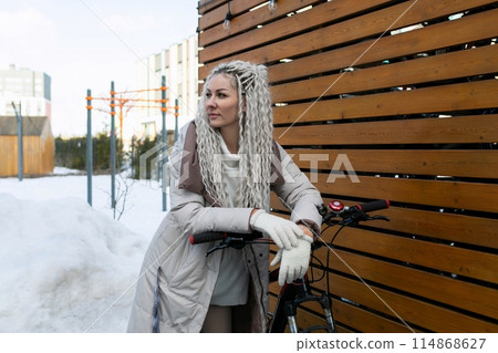 Woman Riding Bike Down Snow Covered Street Woman Riding Bike Down Snow Covered Street 114868627