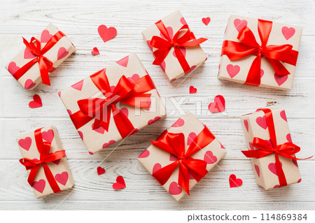 Top view photo of valentine day decorations gift box with red ribbon bow on colored background. Holiday gift boxes with top view 114869384