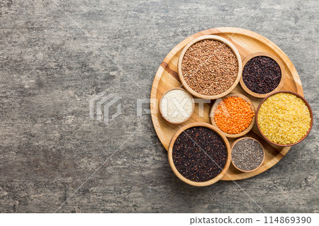 Various superfoods in smal bowl on colored background. Superfood as rice, chia, quinoa, lentils, nuts, sesame seeds, almonds. top view Various superfoods in smal bowl on colored background. Superfood as rice, chia, quinoa, lentils, nuts, sesame seeds, almonds. top view 114869390