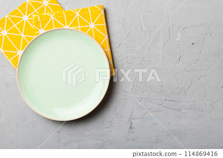 Top view on colored background empty round green plate on tablecloth for food. Empty dish on napkin with space for your design 114869416