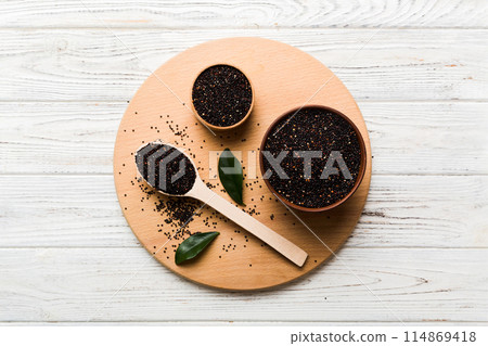 quinoa seeds in bowl and spoon on colored background. Healthy kinwa in small bowl. Healthy superfood quinoa seeds in bowl and spoon on colored background. Healthy kinwa in small bowl. Healthy superfood 114869418