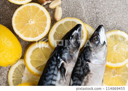 Uncooked mackerel sea fish with lemons and garlic, culinary recipe Uncooked mackerel sea fish with lemons and garlic, culinary recipe 114869455