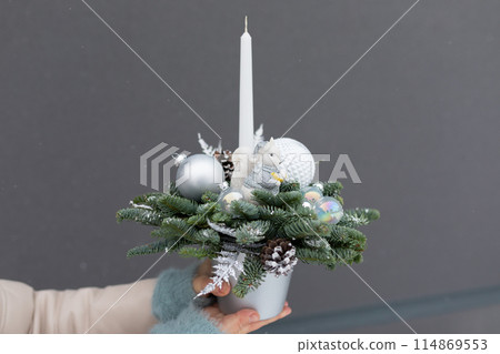 Person Holding Christmas Arrangement With Candle Person Holding Christmas Arrangement With Candle 114869553