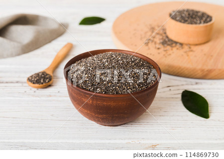 Chia seeds in bowl and spoon on colored background. Healthy Salvia hispanica in small bowl. Healthy superfood 114869730