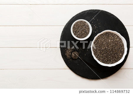 Chia seeds in bowl and spoon on colored background. Healthy Salvia hispanica in small bowl. Healthy superfood 114869732