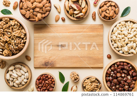mixed nuts in wooden bowl. Mix of various nuts on colored background. pistachios, cashews, walnuts, hazelnuts, peanuts and brazil nuts mixed nuts in wooden bowl. Mix of various nuts on colored background. pistachios, cashews, walnuts, hazelnuts, peanuts and brazil nuts 114869761