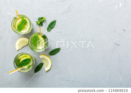 Caipirinha, Mojito cocktail, vodka or soda drink with lime, mint and straw on table background. Refreshing beverage with mint and lime in glass top view flat lay Caipirinha, Mojito cocktail, vodka or soda drink with lime, mint and straw on table background. Refreshing beverage with mint and lime in glass top view flat lay 114869810