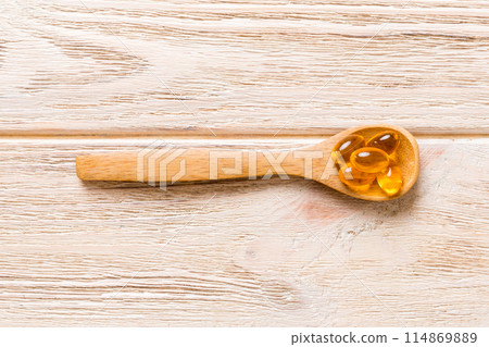 Vitamin omega capsules in a spoon on a colored background. Pills served as a healthy meal. Red soft gel vitamin supplement capsules on spoon Vitamin omega capsules in a spoon on a colored background. Pills served as a healthy meal. Red soft gel vitamin supplement capsules on spoon 114869889