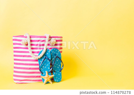 Stylish bag with beach accessories . Summer holiday concept. beach bag with straw hat with space for text Stylish bag with beach accessories . Summer holiday concept. beach bag with straw hat with space for text 114870278