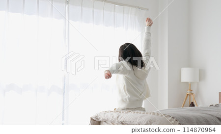 A woman who gets up in the morning and stretches A woman who gets up in the morning and stretches 114870964