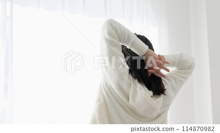 A woman who gets up in the morning and stretches 114870982
