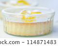 A dessert with a yellow center and white powdered sugar on top 114871483