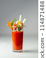 A glass of Bloody Mary drink with a celery spear and an orange slice on top 114871488