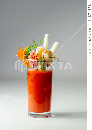 A glass of Bloody Mary drink with a celery spear and an orange slice on top 114871488