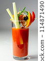 A glass of Bloody Mary drink with a celery spear and an orange slice on top 114871490