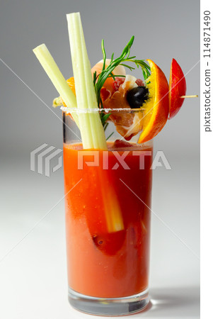 A glass of Bloody Mary drink with a celery spear and an orange slice on top 114871490