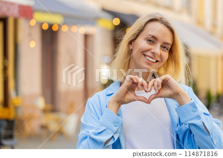 Woman makes symbol of love showing heart sign to camera charity gratitude donation positive feelings Woman makes symbol of love showing heart sign to camera charity gratitude donation positive feelings 114871816