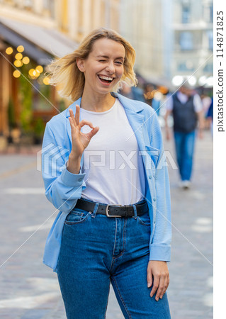 Young woman looking approvingly at camera showing OK gesture positive like sign Okay celebrate win Young woman looking approvingly at camera showing OK gesture positive like sign Okay celebrate win 114871825