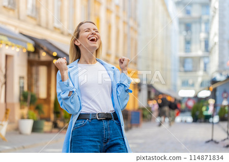 Excited happy woman tourist shouts celebrating success winning triumph career achievement good news 114871834