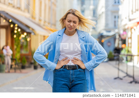 Woman tourist feeling sudden strong abdominal stomach ache diarrhea gastritis problem on city street Woman tourist feeling sudden strong abdominal stomach ache diarrhea gastritis problem on city street 114871841