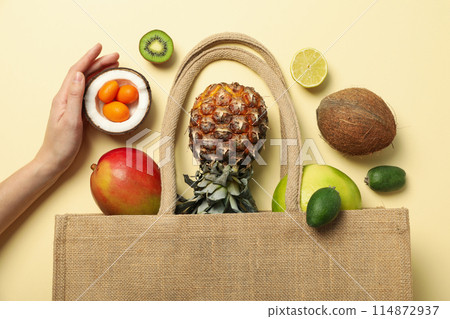 Set of tropical fruit in bag and hand on beige background, top view Set of tropical fruit in bag and hand on beige background, top view 114872937