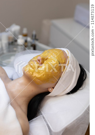 A girl at a cosmetologist does cosmetic procedures. Alginate mask A girl at a cosmetologist does cosmetic procedures. Alginate mask 114873119