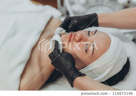 A girl at a cosmetologist does cosmetic procedures. Skin cleansing 114873146