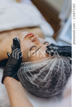 A girl at a cosmetologist does cosmetic procedures. Skin cleansing 114873165