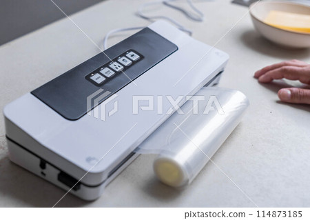 Man using sealer for vacuum packing with plastic bag  114873185