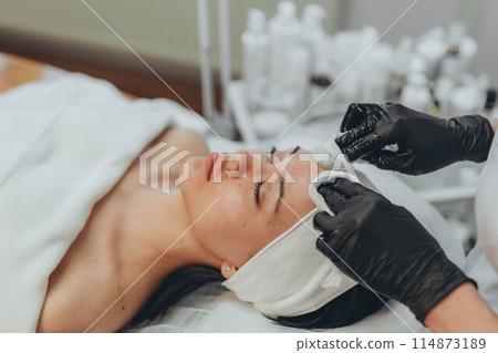 woman at the cosmetologist. She has problem skin and acne. 114873189