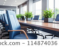 Conference room has tables, chairs, and plants, creating welcoming ambiance 114874036