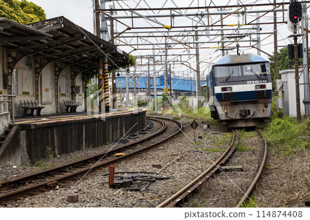 Electric locomotive passing through a station 114874408