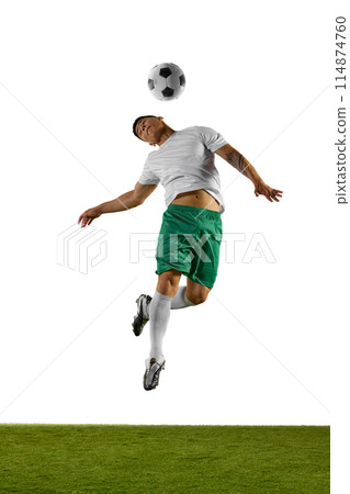 Young man, soccer player jumps in mid-air prepares to head soccer ball, with his body twisted in motion on field against white studio background. 114874760