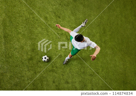 Bird's eye view of young athletic man, soccer player in action, ready to make game-changing play on field. Bird's eye view of young athletic man, soccer player in action, ready to make game-changing play on field. 114874834