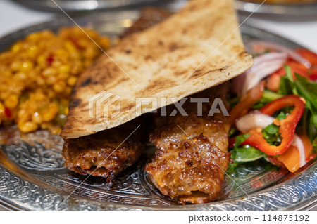 Grilled Turkish Adana, Urfa Kebab with grilled vegetables, onion and rice on plate. Adana durum. High quality photo Grilled Turkish Adana, Urfa Kebab with grilled vegetables, onion and rice on plate. Adana durum. High quality photo 114875192