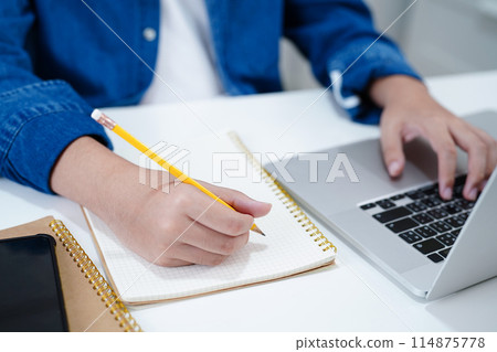 Asian teenage student write homework, study lesson for exam online learning education. 114875778