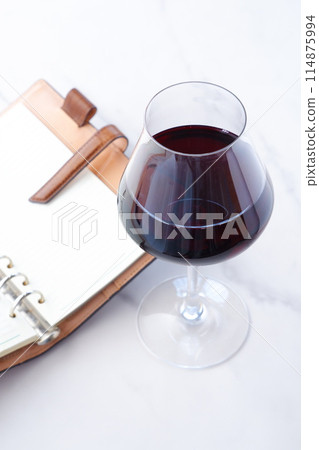 一邊喝紅酒一邊在環形筆記本上寫日記 一邊喝紅酒一邊在環形筆記本上寫日記 114875994