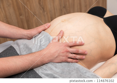 Pregnant Woman Receiving Osteopathic Belly Treatment 114876102