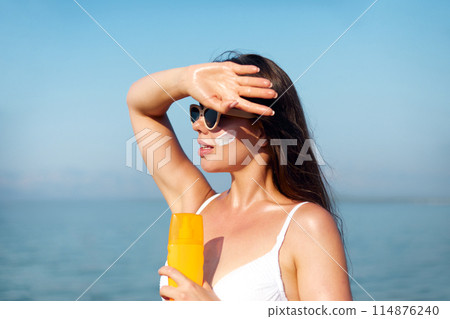 Beautiful Woman Face Portrait Beauty Skin Care Concept. Suncream. Suntan Lotion Beautiful Woman Applying on beautiful on Face. Sunscreen Solar Cream. Sun protection.The Girl Uses Moisturizer Sunblock 114876240