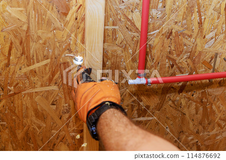Installing connecting PVC plastic water pipes to walls of home Installing connecting PVC plastic water pipes to walls of home 114876692