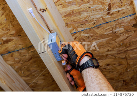 Installing power junction box for LED recessed ceiling lights in new residence by an electrician 114876720