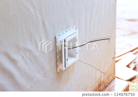 Electrical box is mounted outside on deep plastic wall mounted electrical box that is weatherproof Electrical box is mounted outside on deep plastic wall mounted electrical box that is weatherproof 114876750