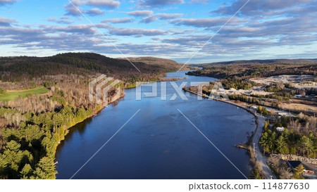 Flying over a beautiful lake in Canada that is surrounded by pine trees - drone photography Flying over a beautiful lake in Canada that is surrounded by pine trees - drone photography 114877630