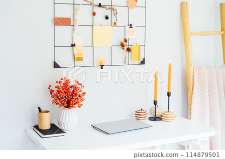 Home office desk with closed laptop, grid mood board with fall colors palette notes mockups and seasonal decor like candles, flowers, pumpkins. Autumn inspiration and cozy mood. Hygge home fall decor Home office desk with closed laptop, grid mood board with fall colors palette notes mockups and seasonal decor like candles, flowers, pumpkins. Autumn inspiration and cozy mood. Hygge home fall decor 114879501