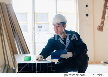 Carpenter checking materials at a construction site Carpenter checking materials at a construction site 114879930