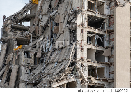 Collapsed building with exposed floors and structural damage 114880032