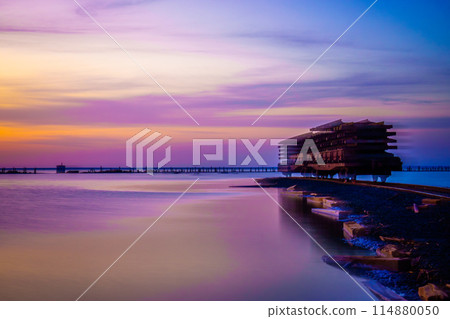 Stunning sunset hues over a modern waterfront building Stunning sunset hues over a modern waterfront building 114880050