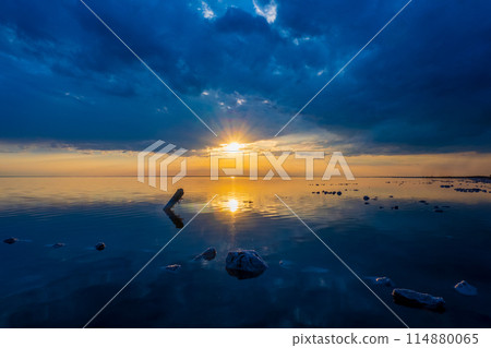 Sunset over tranquil lake with dynamic cloud cover Sunset over tranquil lake with dynamic cloud cover 114880065